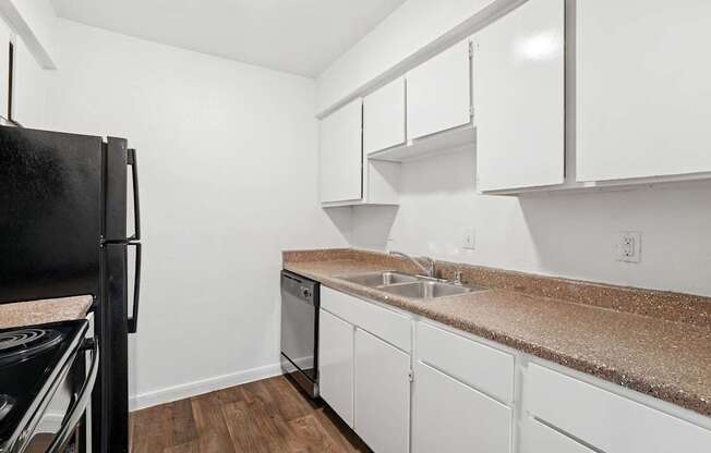 A kitchen with white cabinets and a granite countertop.