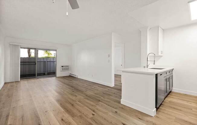 A kitchen with a white counter and wooden floors.
