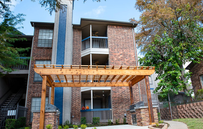 the view of a brick apartment building with a wooden porch