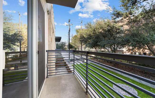 A balcony with a metal railing and a white painted symbol on the grass.