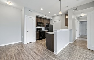 a renovated kitchen and living room with white walls and wood flooring