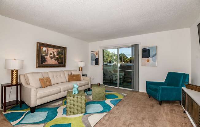 a living room with a couch and chair and a sliding glass door