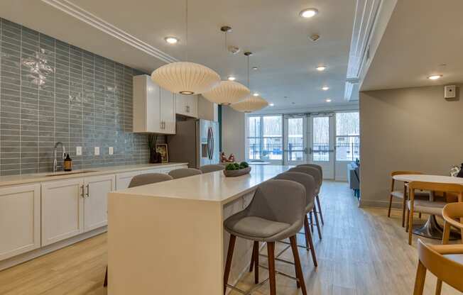 an open kitchen and dining area with a long counter and chairs at The Bella at Westchester, Virginia