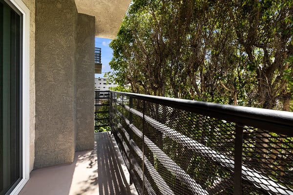 a balcony with a black railing and trees at NOHO GALLERY Apartments, California, 91601