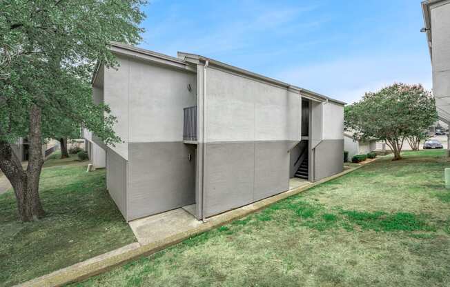 a modern house with a lawn and trees