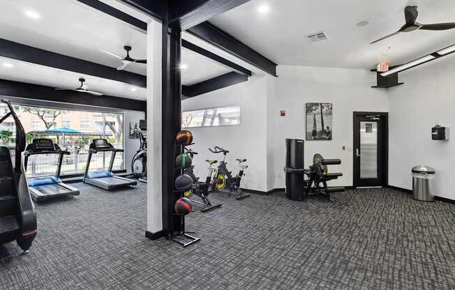A gym with treadmills, exercise bikes, and weights.