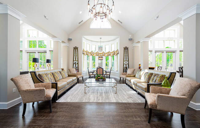 a living room with couches and chairs and a chandelier