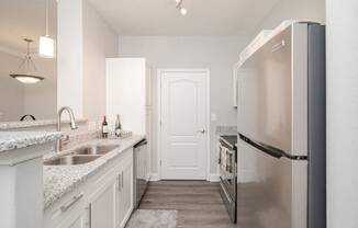 a kitchen with stainless steel appliances and white cabinets