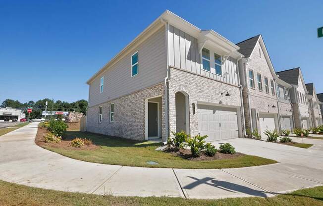 an exterior view of a gray and with a driveway and a garage door