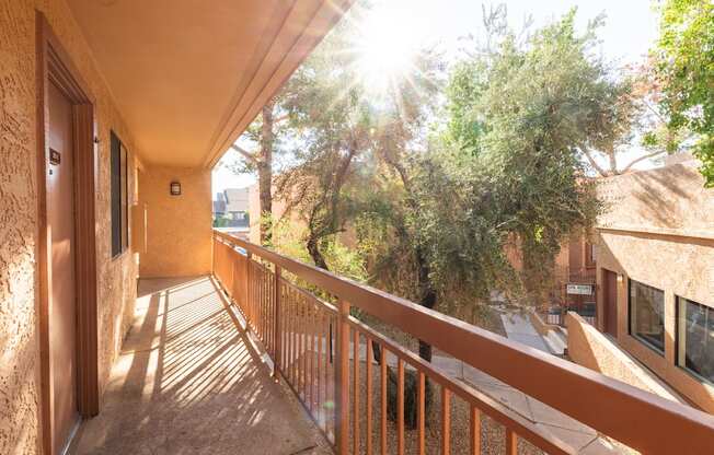 A balcony with a railing and a view of trees and buildings.
