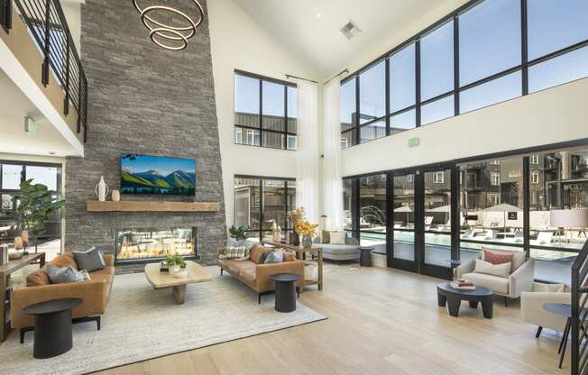 a living room with couches and chairs and a large stone fireplace