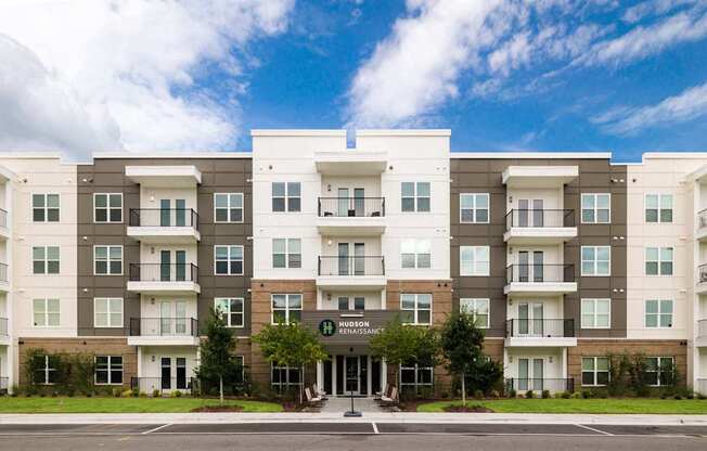 A large apartment complex with a green lawn in front.