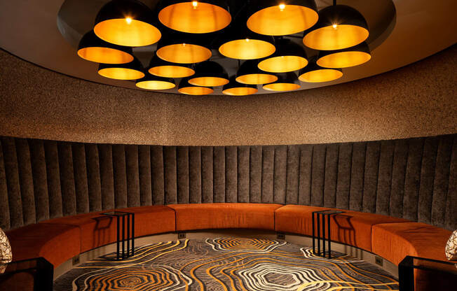 a circular seating area with a large circular chandelier above it