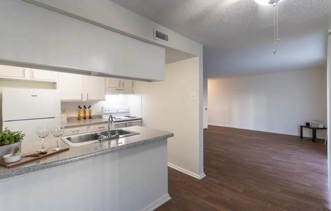 This is a photo of the kitchen and living room from the dining room in the 871 square foot 2 bedroom, 2 bath apartment at Princeton Court Apartments in the Vickery Meadow neighborhood of Dallas, Texas.
