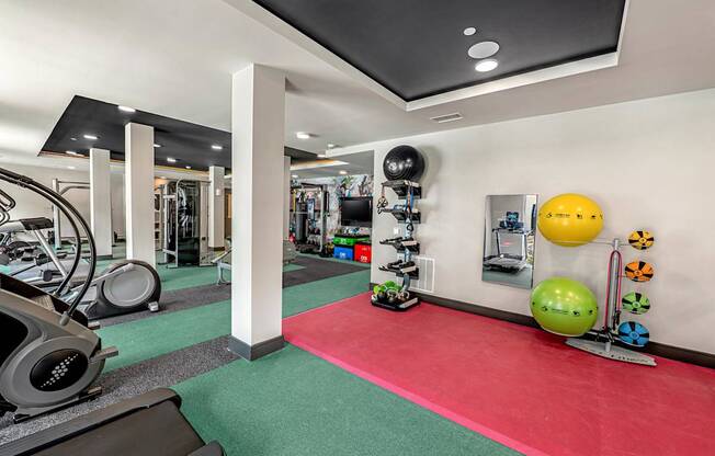 A gym with a red mat in the middle of the room.