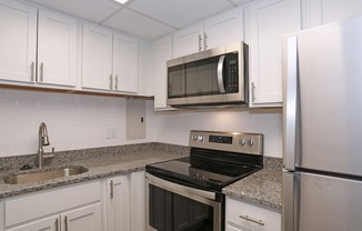 a kitchen with white cabinets and granite countertops