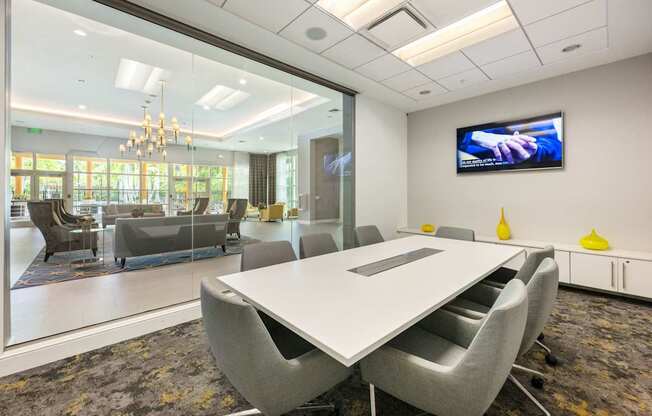 a conference room with a table and chairs and a television