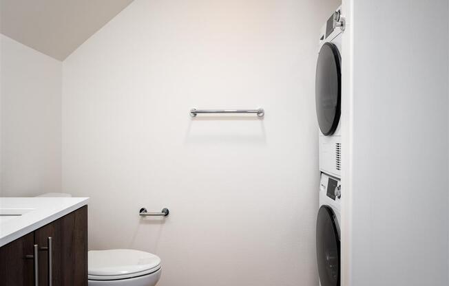 a bathroom with a toilet and a washing machine in it