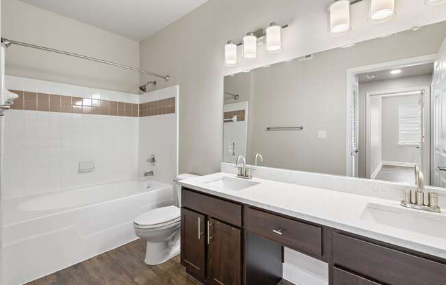 a bathroom with a large mirror and a sink and a toilet at The Verandah, Austin, TX