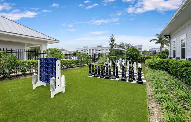 A giant chess set is set up on a lawn.