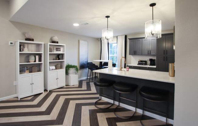 a kitchen and dining room with black cabinets and a striped rug