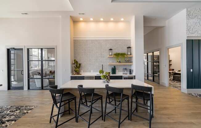 a dining room with a table and chairs in front of a kitchen