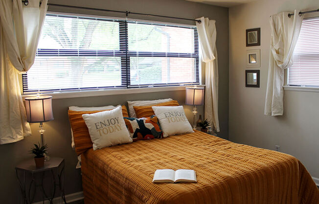 a bedroom with a bed with an open book on it