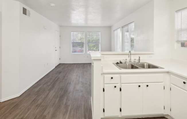 a white kitchen with a sink and white cabinets