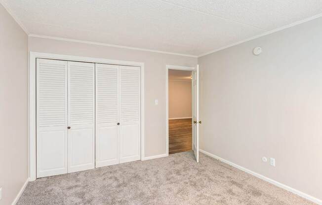 A room with a white door and a carpeted floor.