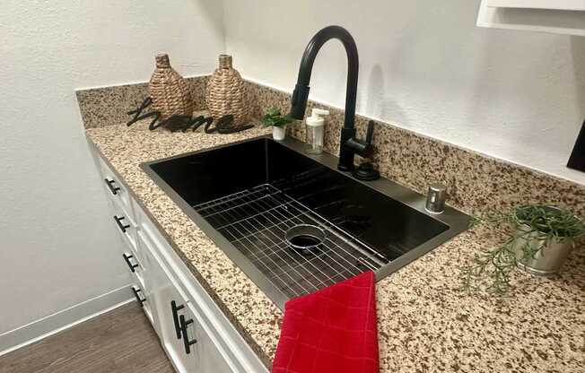 A kitchen counter with a sink and a red towel at Willow Tree Apartments, California, 90505