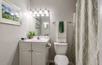 bathroom remodeled. white counters, white cabinets, tub, and large mirror.