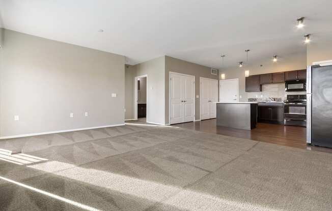 A spacious room with a kitchen area in the background.