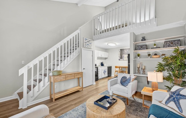 A living room with a staircase and a dining area.at Lofts of Wilmington, North Carolina, 28405