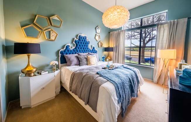 a blue and white bedroom with a bed and a window