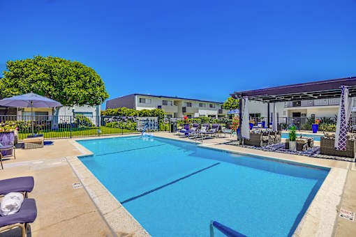 A large outdoor swimming pool with loungers and umbrellas.