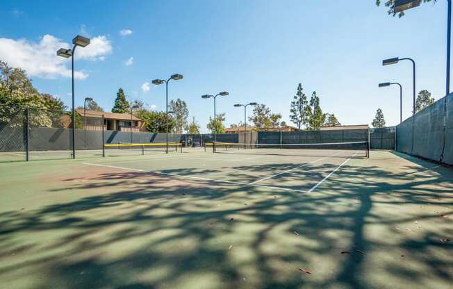 a tennis court at a school with trees in the background