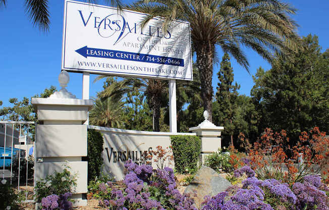 A Versailles Apartment Leasing Center sign is displayed in front of a building.