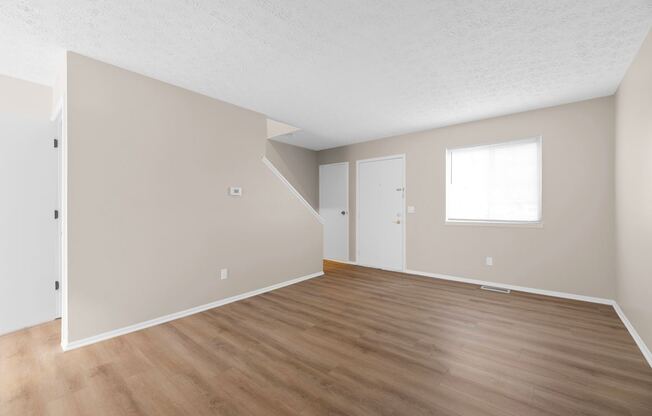 Empty room with wooden floors and white walls.