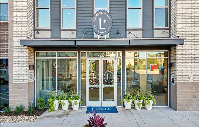 The entrance to a Lululemon store with a blue doormat and potted plants.
