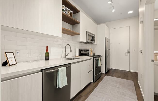A kitchen with white cabinets and a grey floor.