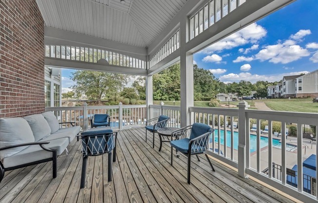 a covered porch with a pool and furniture on it