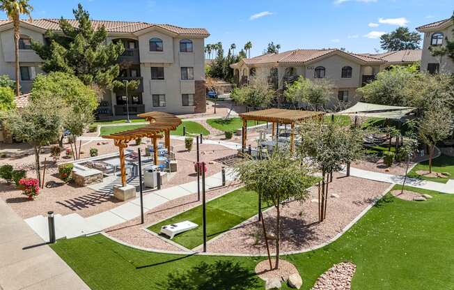 A sunny day at a residential complex with a playground and trees.