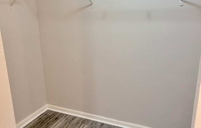 an empty closet in a home with wood flooring