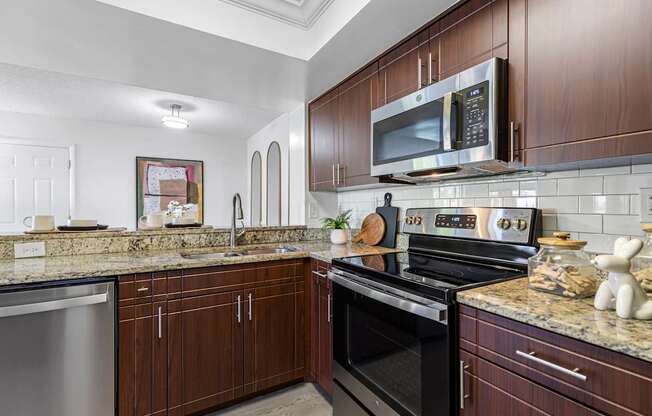 A kitchen with dark wood cabinets and stainless steel appliances.