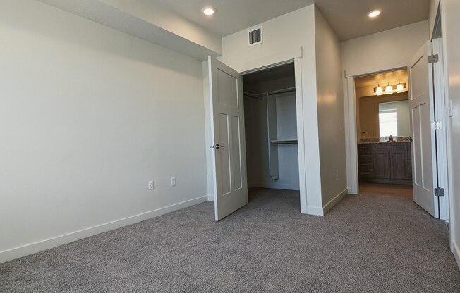 A bedroom with gray carpet and white walls