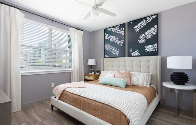 bedroom with wood-style floors, large window, and ceiling fan at Lake Nona Concorde Apartments