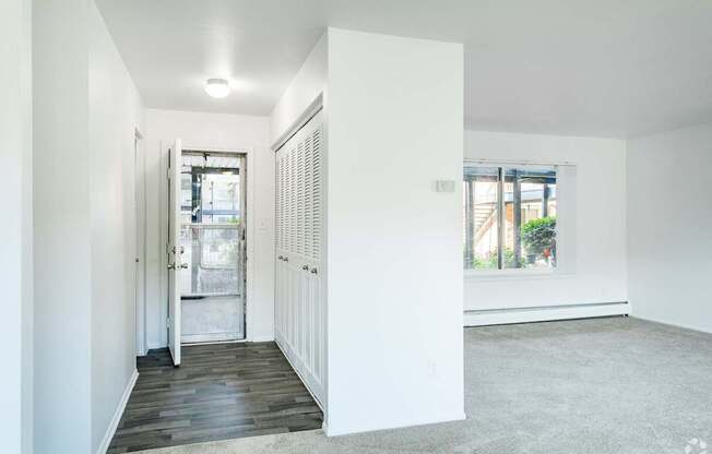 a living room with white walls and a door to a bathroom