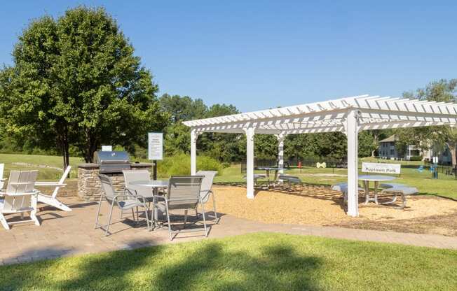 a picnic area with a table and chairs under a white canopy
