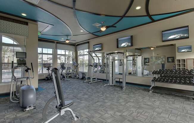 Free weights, benches, and other fitness equipment in fitness center at Lake Nona Water Mark in Orlando, FL 32827