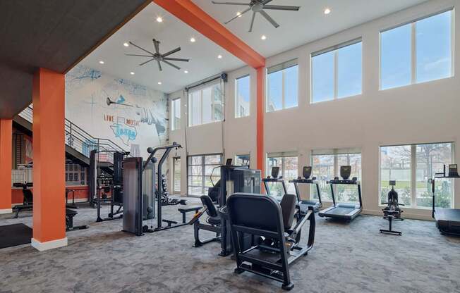 A gym with a variety of equipment including treadmills, weights, and exercise machines.